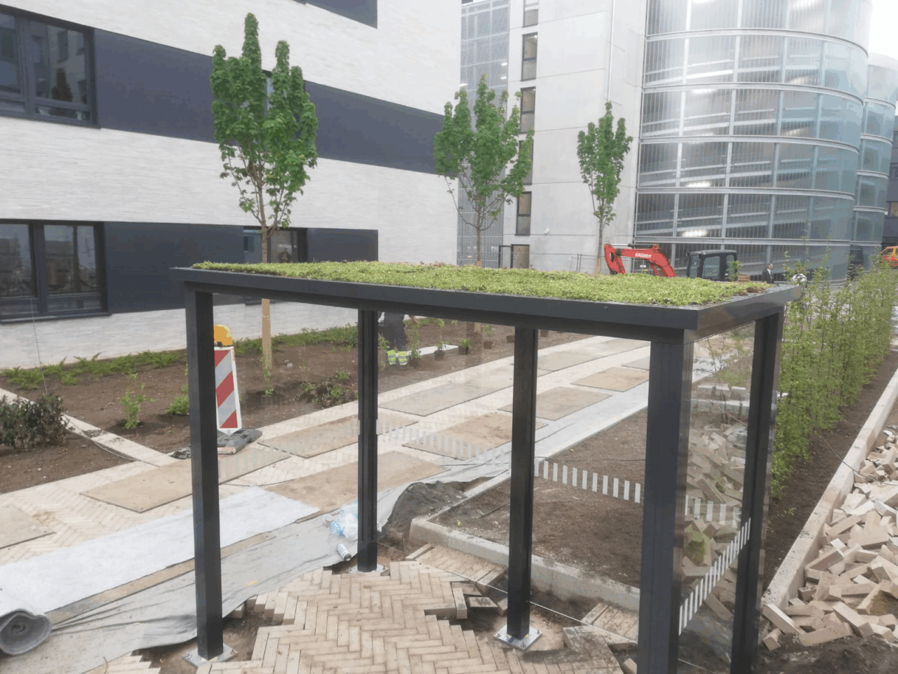 Raucherunterstand mit Gründach und Glaswänden von SHARP.