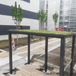 Raucherunterstand mit Gründach und Glaswänden von SHARP.