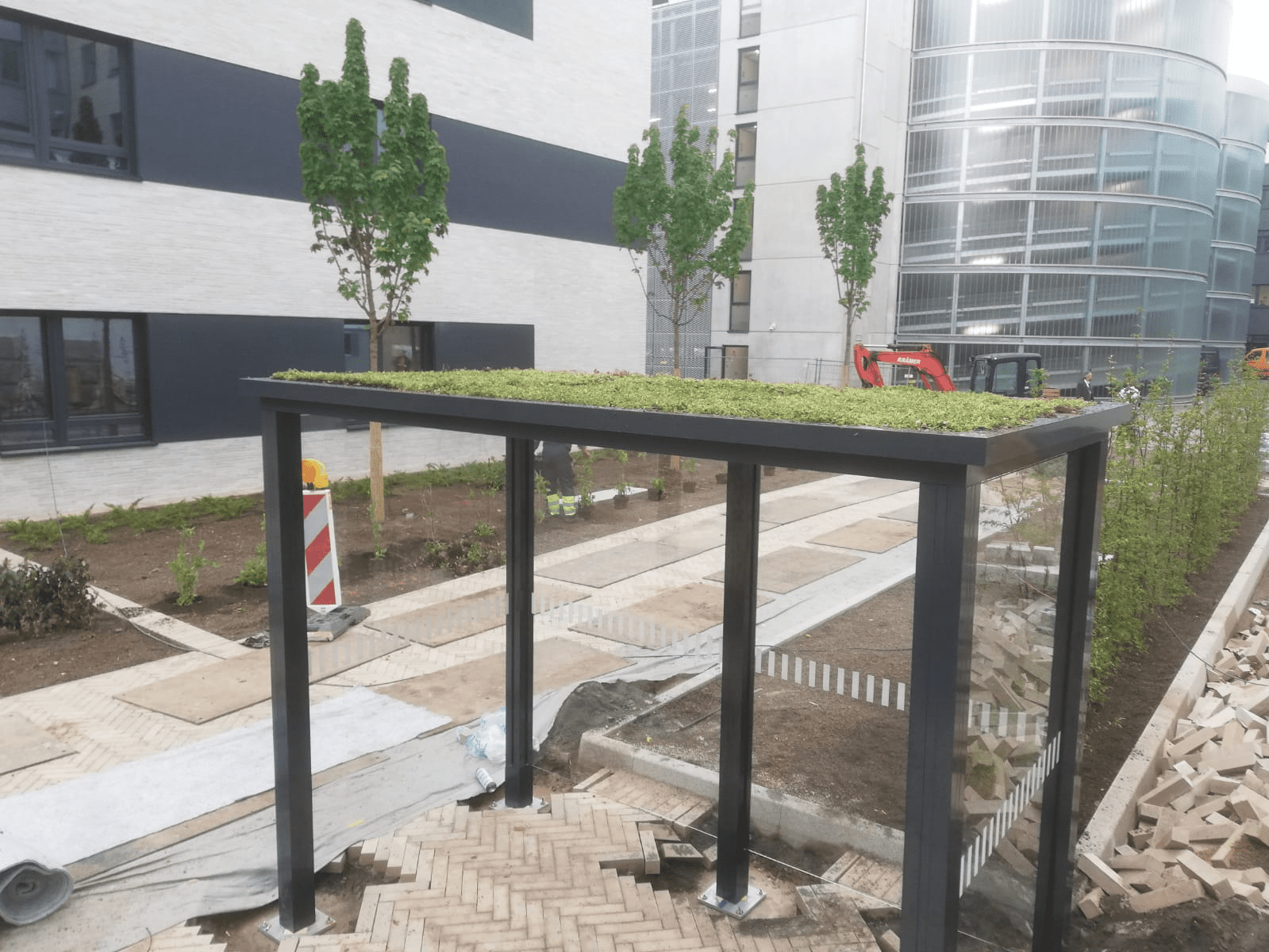 Raucherunterstand mit Gründach und Glaswänden von SHARP.