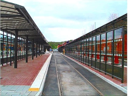 Terminal mit Wartehallen an Bahnhof inklusive Sitzbaenken, Fahrradstaendern und Informationstafeln in Angered, Schweden.