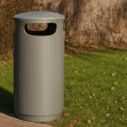 Grauer Abfallbehälter draußen im Park.